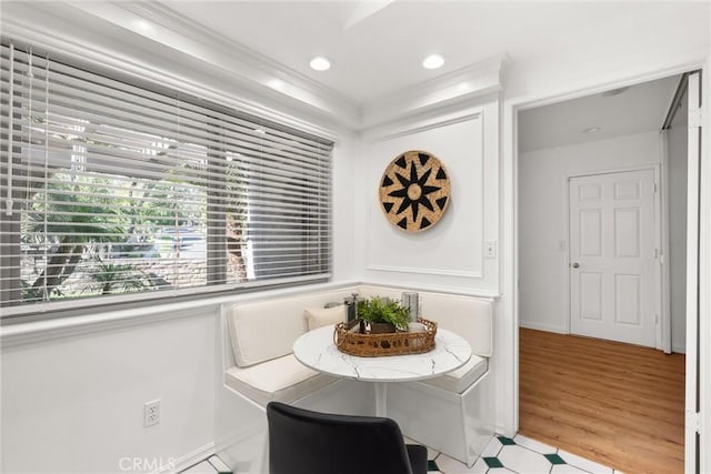 dining space with light hardwood / wood-style flooring and ornamental molding