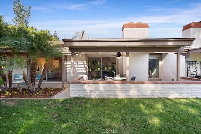 rear view of house featuring a lawn, ceiling fan, and a patio