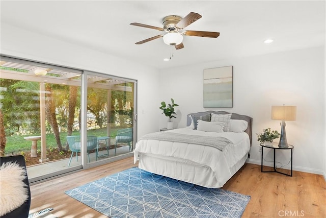 bedroom with wood-type flooring, access to outside, and ceiling fan