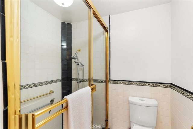 bathroom featuring toilet, tile walls, and walk in shower