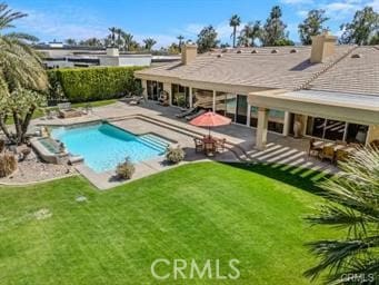 view of swimming pool featuring a lawn and a patio area