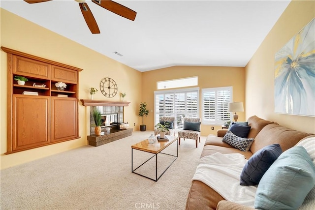 carpeted living room with a premium fireplace, ceiling fan, and lofted ceiling