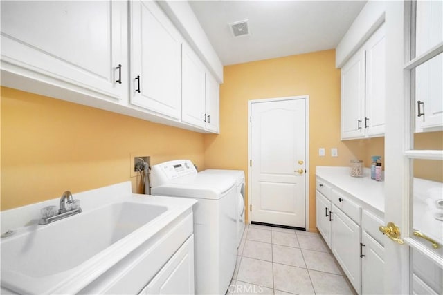 washroom with cabinets, independent washer and dryer, light tile patterned flooring, and sink