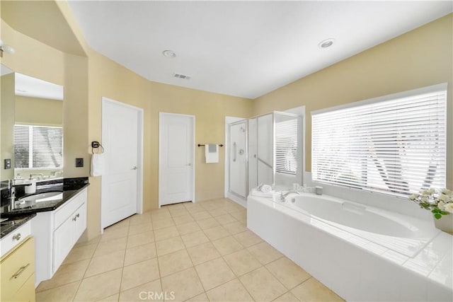 bathroom with tile patterned floors, vanity, and plus walk in shower