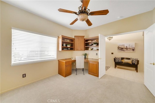 home office featuring light carpet and ceiling fan