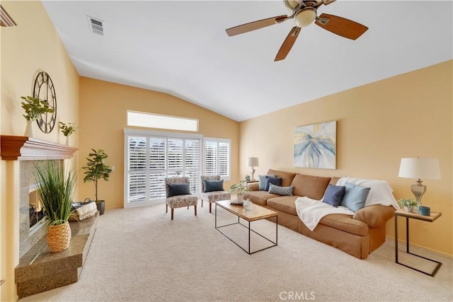 living room featuring carpet flooring, ceiling fan, a fireplace, and vaulted ceiling