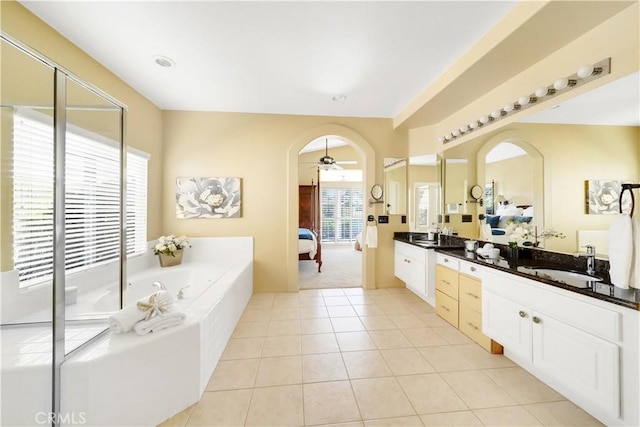 bathroom with vanity, tile patterned floors, ceiling fan, and tiled tub