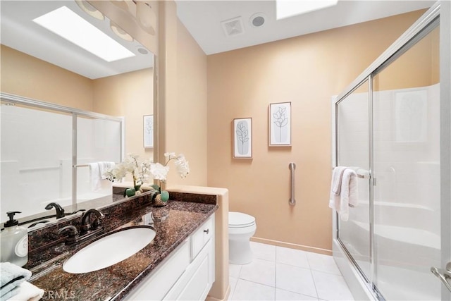 bathroom featuring toilet, vanity, tile patterned floors, and a shower with shower door