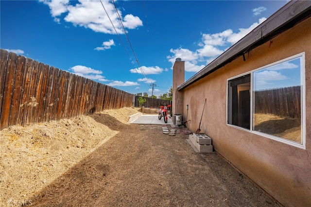 view of side of home with a patio and cooling unit