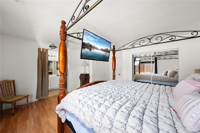 bedroom with ensuite bath and light hardwood / wood-style flooring