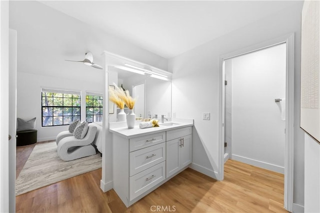 bathroom with hardwood / wood-style floors, vanity, and ceiling fan