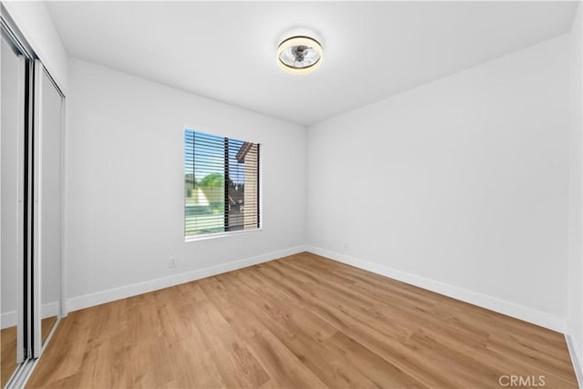 unfurnished bedroom featuring a closet and light hardwood / wood-style flooring