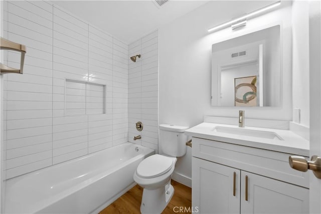 full bathroom featuring hardwood / wood-style flooring, vanity, tiled shower / bath combo, and toilet