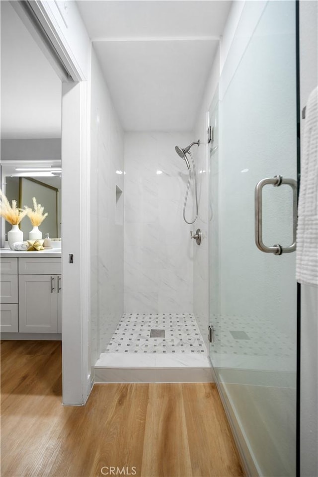 bathroom with vanity, hardwood / wood-style flooring, and walk in shower