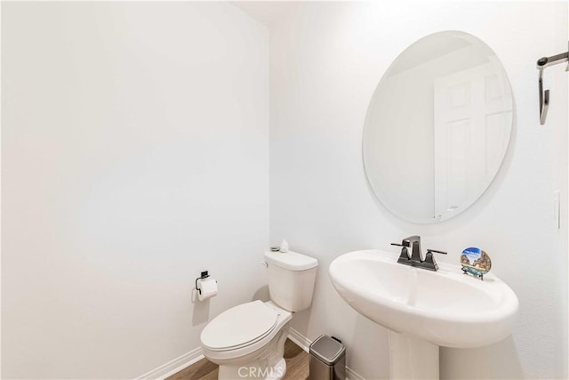 bathroom featuring sink, wood-type flooring, and toilet