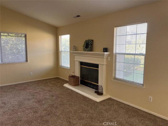 unfurnished living room with carpet and plenty of natural light