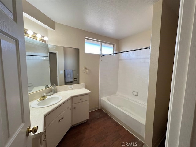 bathroom with shower / bath combination, vanity, wood-type flooring, and a textured ceiling