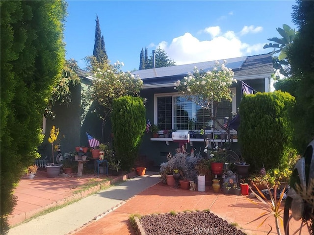 view of front of house with a patio area and solar panels