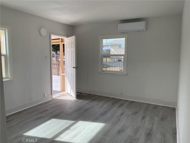 empty room featuring dark wood-type flooring and a wall unit AC