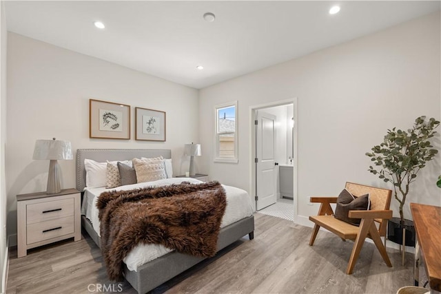 bedroom with light hardwood / wood-style floors and ensuite bathroom