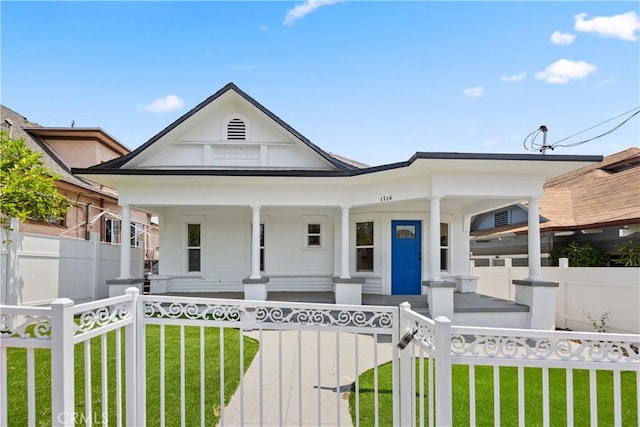 view of front of home featuring covered porch and a front lawn