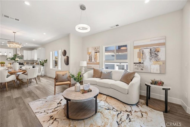 living room with a chandelier and light hardwood / wood-style floors