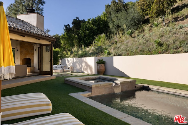 view of yard featuring an outdoor living space with a fireplace, a patio area, and a swimming pool with hot tub