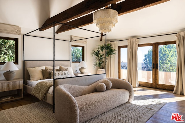 bedroom with beam ceiling, multiple windows, and french doors