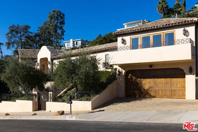 mediterranean / spanish home featuring a balcony and a garage