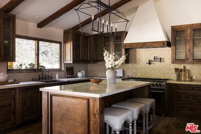 kitchen featuring a center island, tasteful backsplash, dark hardwood / wood-style flooring, premium range hood, and stainless steel stove