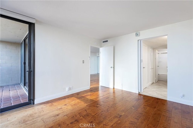 interior space featuring connected bathroom and light hardwood / wood-style flooring