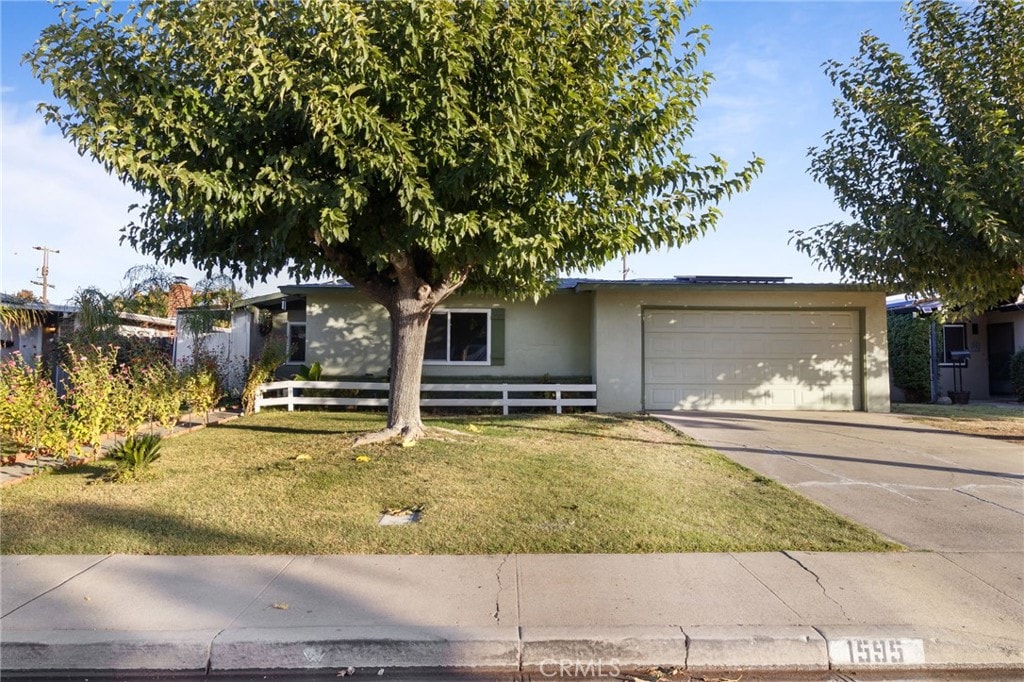 ranch-style house featuring a garage and a front lawn