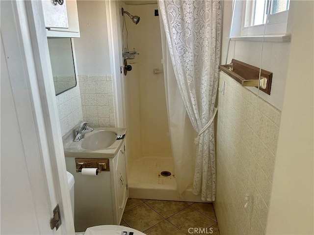 401 Fenmore Dr, Barstow, CA 92311 - full bathroom featuring tile walls, tile patterned floors, a stall shower, vanity, and a wainscoted wall