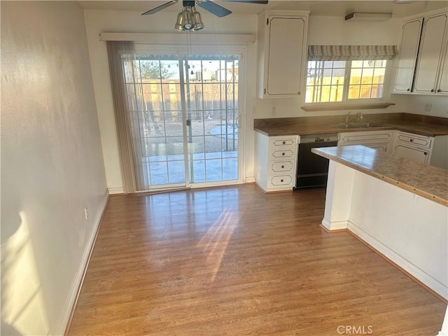 401 Fenmore Dr, Barstow, CA 92311 - kitchen with white cabinetry, dishwashing machine, and healthy amount of natural light