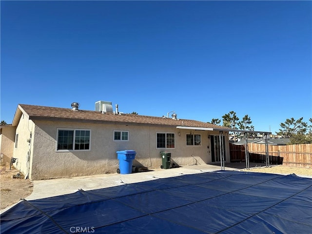 back of property with central AC and a patio area