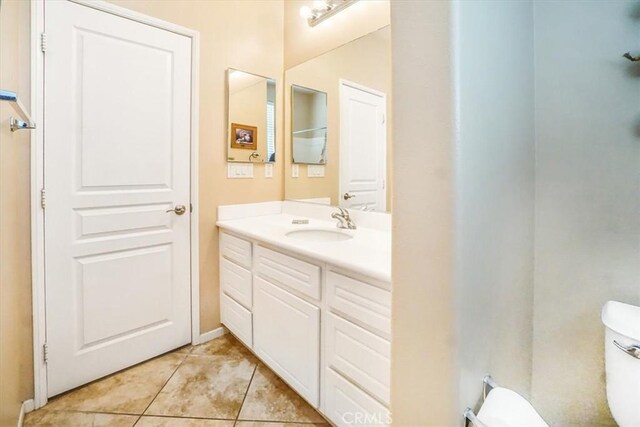 bathroom featuring tile patterned floors, vanity, and toilet