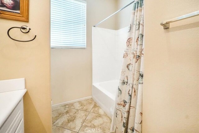 bathroom featuring tile patterned floors, vanity, and shower / bath combo