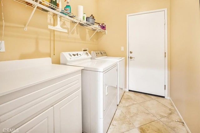 laundry room with washing machine and dryer and light tile patterned floors