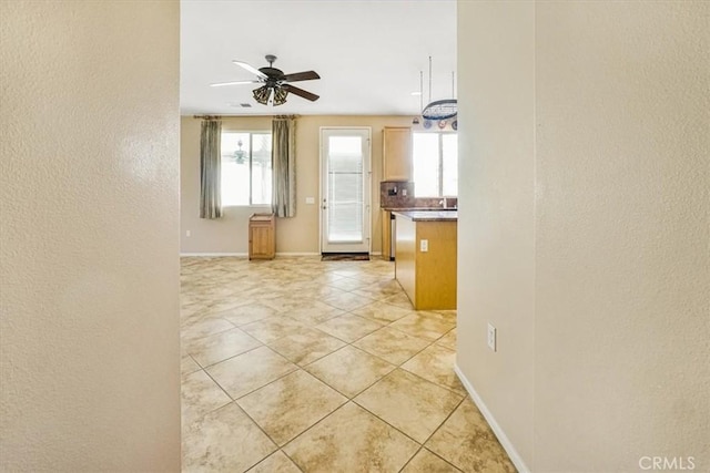 interior space with light tile patterned floors and ceiling fan