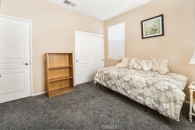 bedroom featuring dark carpet and a closet