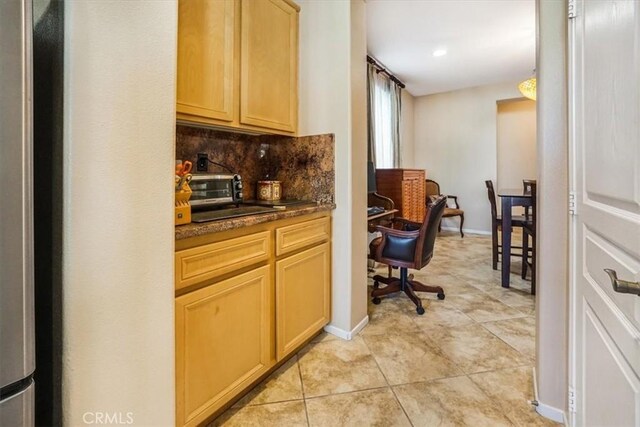 kitchen featuring decorative backsplash, light brown cabinets, and light tile patterned floors