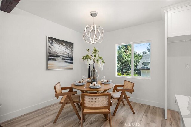 dining space featuring light hardwood / wood-style floors and a chandelier