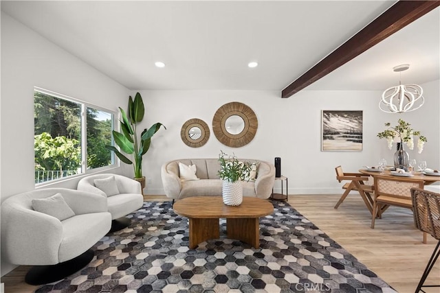 living room with beam ceiling, light hardwood / wood-style flooring, and an inviting chandelier