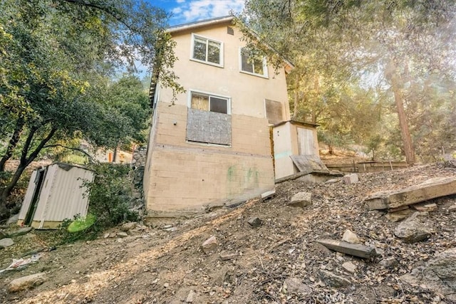 view of side of property with a storage shed