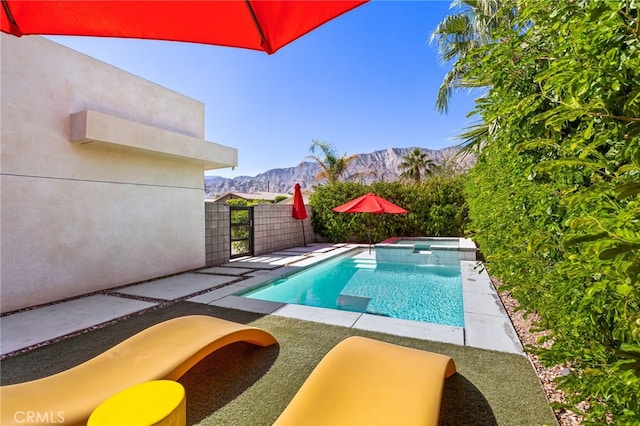 view of pool with a mountain view, an in ground hot tub, and a patio