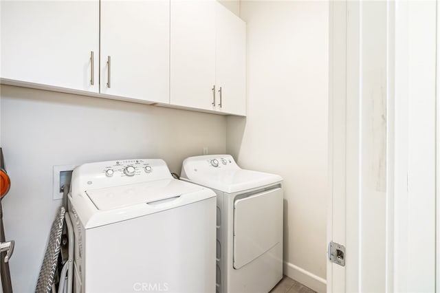 laundry room with washer and dryer and cabinets