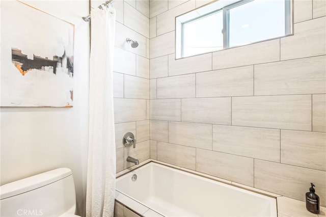 bathroom featuring shower / bathtub combination with curtain and toilet