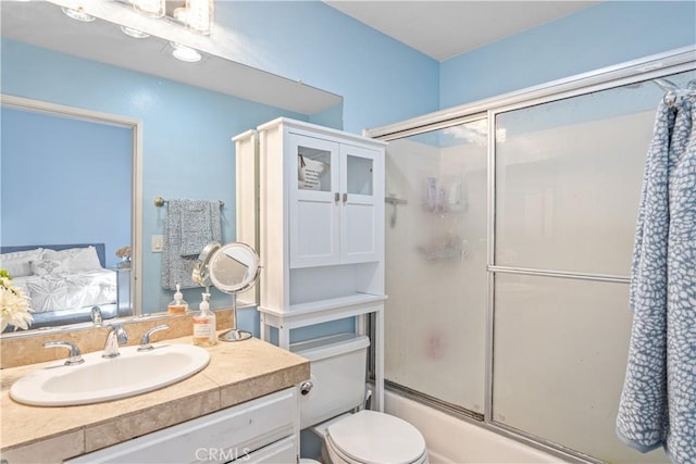 full bathroom featuring vanity, enclosed tub / shower combo, and toilet