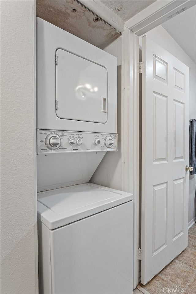 washroom featuring stacked washer / drying machine