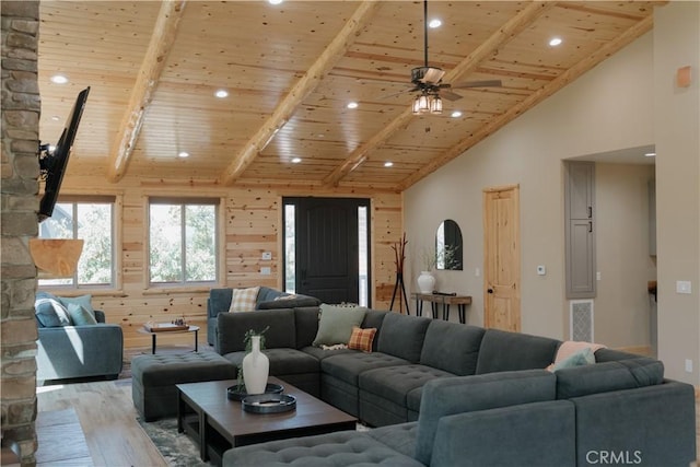 living room with high vaulted ceiling, wooden walls, beam ceiling, light hardwood / wood-style floors, and wood ceiling